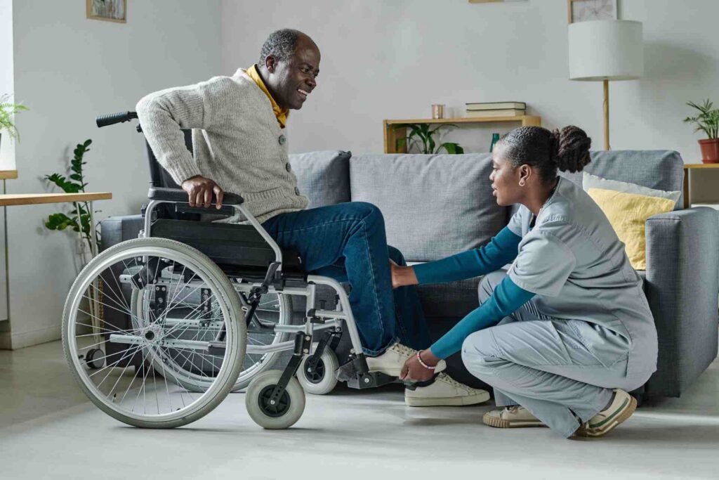 Caregiver assisting adult with intellectual disability in wheelchair at home